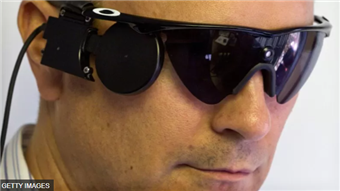 사람의 망막에 이식된 칩이 안경에 부착된 카메라와 무선으로 송신받고 있는 모습